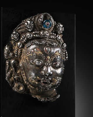 Lot 20 - A PARCEL-GILT SILVER REPOUSSÉ MASK OF BHAIRAVA, NEPAL, 16TH-17TH CENTURY