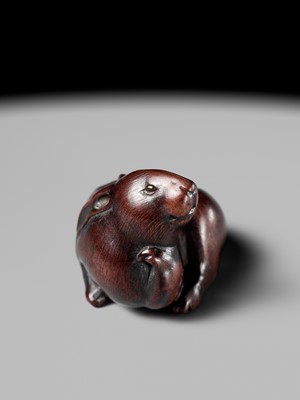 Lot 146 - MASANOBU: A NAGOYA SCHOOL WOOD NETSUKE OF A HARE WITH AMBER EYES