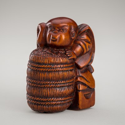 Lot 1355 - KYO: A RARE WOOD NETSUKE OF FUKUSUKE WITH A RICE BALE