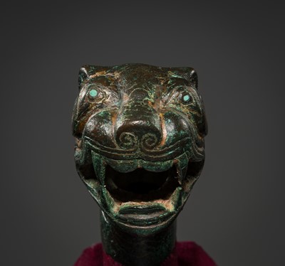 Lot 112 - A TURQUOIZE- AND SILVER-INLAID BRONZE ‘TIGER’ FINIAL, EASTERN HAN DYNASTY