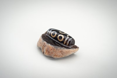 Lot 1523 - A LARGE AND RARE AGATE MATRIX ‘DZI BEAD’ CARVING, 19TH CENTURY