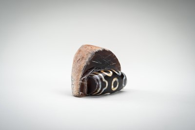 Lot 1523 - A LARGE AND RARE AGATE MATRIX ‘DZI BEAD’ CARVING, 19TH CENTURY