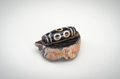 Lot 1523 - A LARGE AND RARE AGATE MATRIX ‘DZI BEAD’ CARVING, 19TH CENTURY