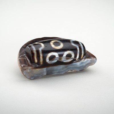 Lot 1523 - A LARGE AND RARE AGATE MATRIX ‘DZI BEAD’ CARVING, 19TH CENTURY