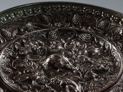 Lot 78 - A LARGE SILVERED BRONZE ‘LION AND GRAPE' MIRROR, TANG DYNASTY