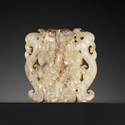 A WHITE AND RUSSET JADE ‘BEAST MASK AND PHOENIX’ PENDANT, ZHOU DYNASTY