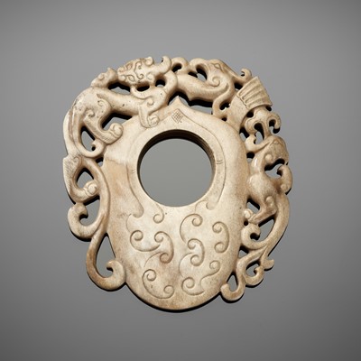 A RETICULATED ‘CHILONG AND PHOENIX’ IVORY-TONED JADE PENDANT IN THE FORM OF AN ARCHER’S RING, JE, HAN DYNASTY