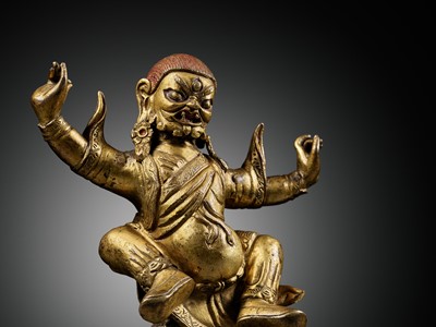 Lot 19 - A GILT-BRONZE FIGURE OF GARWA NAGPO DAMCHEN, TIBET, 17TH-18TH CENTURY