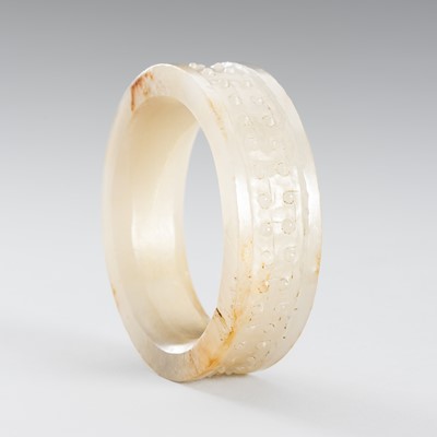 Lot 955 - AN ARCHAISTIC WHITE AND RUSSET JADE BANGLE, QING DYNASTY