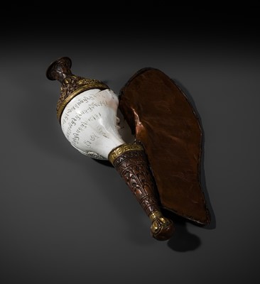 Lot 29 - A CARVED CONCH-SHELL TRUMPET, DUNG DKAR, WITH PARCEL-GILT COPPER REPOUSSÉ MOUNT