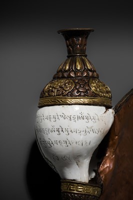 Lot 29 - A CARVED CONCH-SHELL TRUMPET, DUNG DKAR, WITH PARCEL-GILT COPPER REPOUSSÉ MOUNT