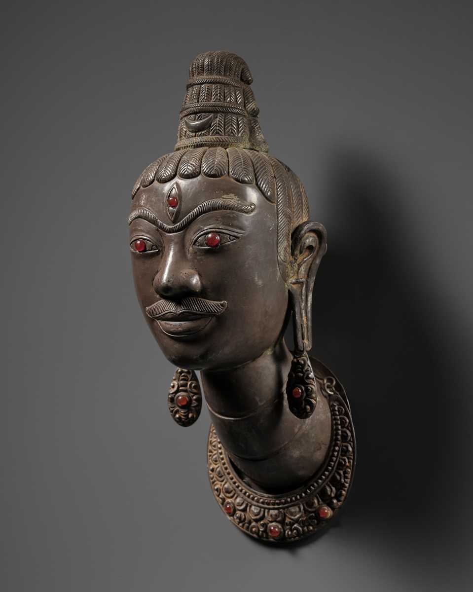 Lot 453 - AN EXCEEDINGLY RARE SILVER REPOUSSÉ HEAD OF SHIVA, LINGAKOSA, WITH MATCHING EARRINGS AND NECKLACE
