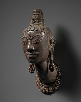 Lot 243 - AN EXCEEDINGLY RARE SILVER REPOUSSÉ HEAD OF SHIVA, LINGAKOSA, WITH MATCHING EARRINGS AND NECKLACE