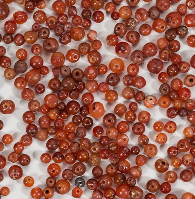 Lot 1003 - A LOT WITH 712 CARNELIAN AGATE BEADS, c. 10TH – 12TH CENTURY