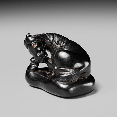 Lot 81 - A LARGE EBONY WOOD NETSUKE OF A RECUMBENT HORSE