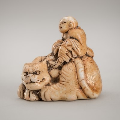 Lot 1227 - A GLAZED CERAMIC NETSUKE OF A RAKAN WITH TIGER