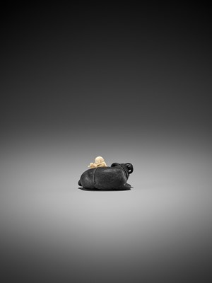 Lot 158 - KAGETOSHI: AN EXQUISITE EBONY WOOD AND IVORY NETSUKE OF AN OX WITH BOKUDO