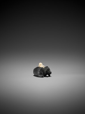 Lot 158 - KAGETOSHI: AN EXQUISITE EBONY WOOD AND IVORY NETSUKE OF AN OX WITH BOKUDO