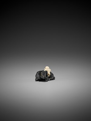 Lot 158 - KAGETOSHI: AN EXQUISITE EBONY WOOD AND IVORY NETSUKE OF AN OX WITH BOKUDO