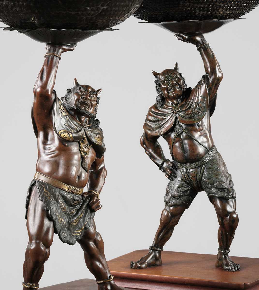 Lot 54 - AKASOFU GYOKKO: A PAIR OF IMPRESSIVE AND LARGE PARCEL-GILT BRONZE FIGURES OF ONI HOLDING ALOFT SOUND BOWLS
