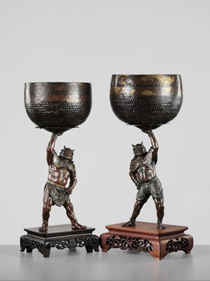 Lot 54 - AKASOFU GYOKKO: A PAIR OF IMPRESSIVE AND LARGE PARCEL-GILT BRONZE FIGURES OF ONI HOLDING ALOFT SOUND BOWLS