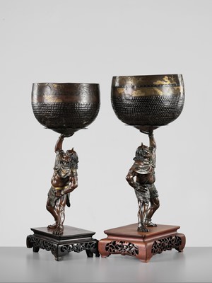 Lot 54 - AKASOFU GYOKKO: A PAIR OF IMPRESSIVE AND LARGE PARCEL-GILT BRONZE FIGURES OF ONI HOLDING ALOFT SOUND BOWLS