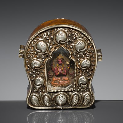 Lot 219 - A COPPER AND REPOUSSÉ SILVER GAU WITH A TSATSA OF CHATURBHUJA AVALOKITESHVARA, TIBET, 19TH-EARLY 20TH CENTURY