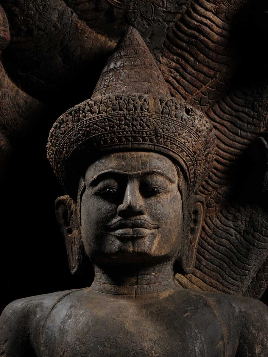 Lot 40 - A MONUMENTAL (215 CM HIGH) AND IMPORTANT WOOD SCULPTURE OF BUDDHA MUCHALINDA, POST-ANGKORIAN PERIOD
