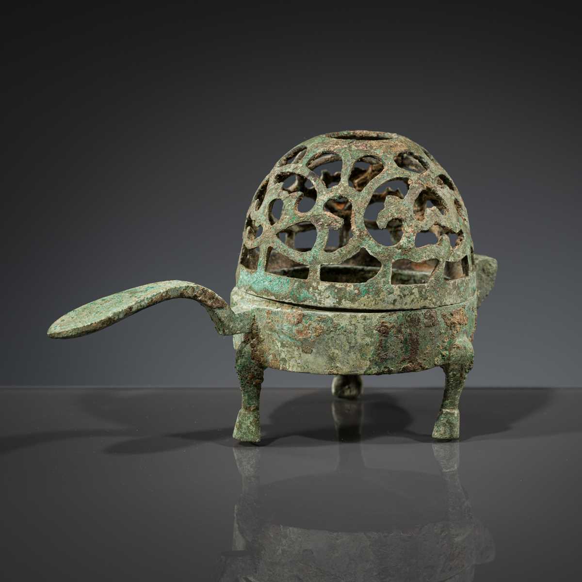 A SMALL BRONZE TRIPOD LAMP WITH A HINGED RETICULATED COVER, HAN DYNASTY