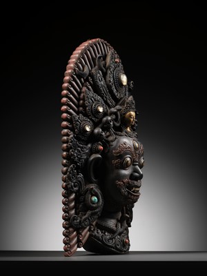 Lot 31 - A LARGE GEMSTONE-INLAID GILT AND POLYCHROME WOOD MASK OF BHAIRAVA, NEPAL, 19TH CENTURY OR EARLIER