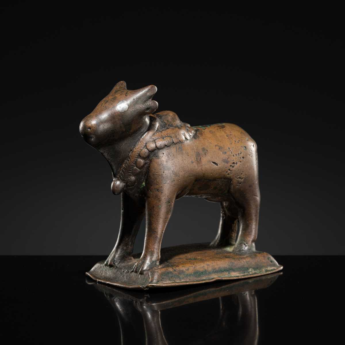 Lot 72 - A SILVER-INLAID BRONZE FIGURE OF NANDI, HIMACHAL PRADESH, 10TH CENTURY