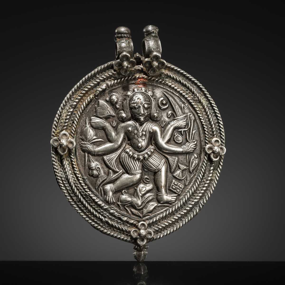 Lot 108 - A SILVER REPOUSSÉ AMULET IN THE SHAPE OF A PIPAL LEAF DEPICTING THE DANCING SHIVA BHAIRAVA, AJMER, 19TH CENTURY
