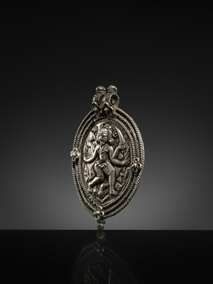 Lot 108 - A SILVER REPOUSSÉ AMULET IN THE SHAPE OF A PIPAL LEAF DEPICTING THE DANCING SHIVA BHAIRAVA, AJMER, 19TH CENTURY