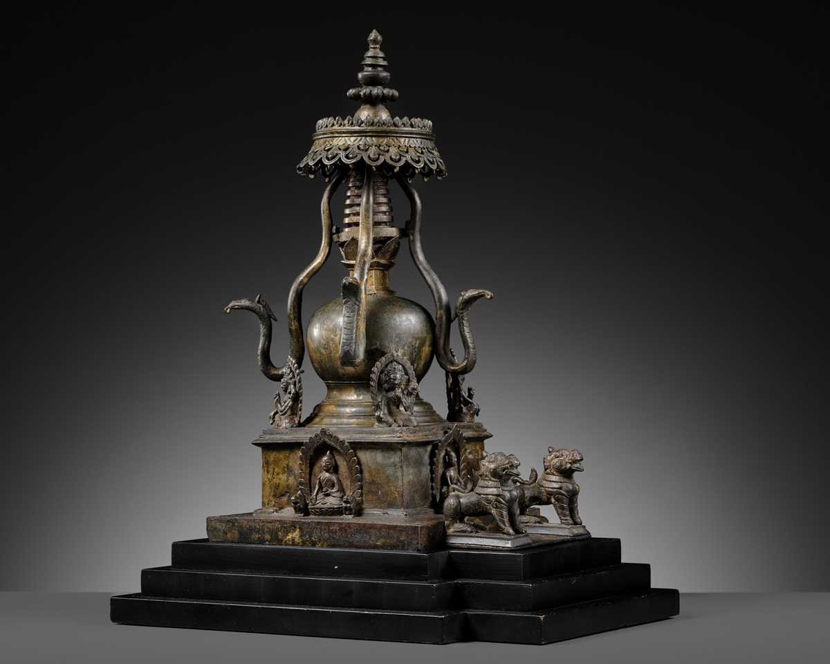 Lot 112 - AN IMPORTANT INSCRIBED BRONZE STUPA WITH FIVE DIRECTIONAL BUDDHAS, FOUR TARAS, GUARDIAN LIONS AND SNAKE CANOPY, 17TH-18TH CENTURY