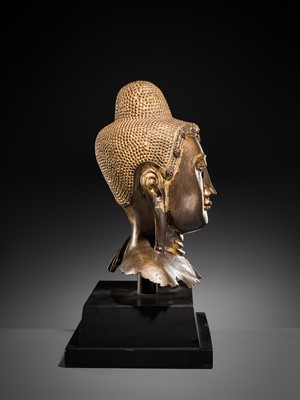 Lot 21 - A RARE AND LARGE GILT-LACQUERED BRONZE BUST OF BUDDHA, EARLY MANDALAY PERIOD