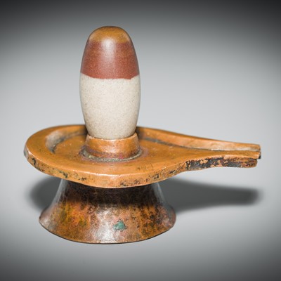Lot 187 - A NARMADA RIVER STONE LINGAM AND COPPER YONI, 19TH CENTURY OR EARLIER