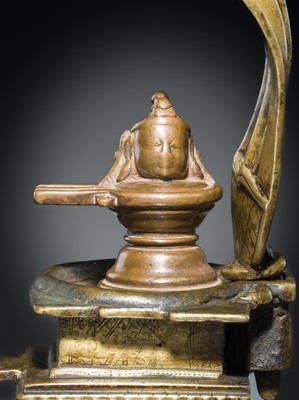 Lot 178 - A COPPER SHIVA MUKHALINGAM AND A BRONZE YONI WITH NANDI AND FIVE-HEADED NAGA CANOPY, MAHARASHTRA, 17TH AND 18TH CENTURY