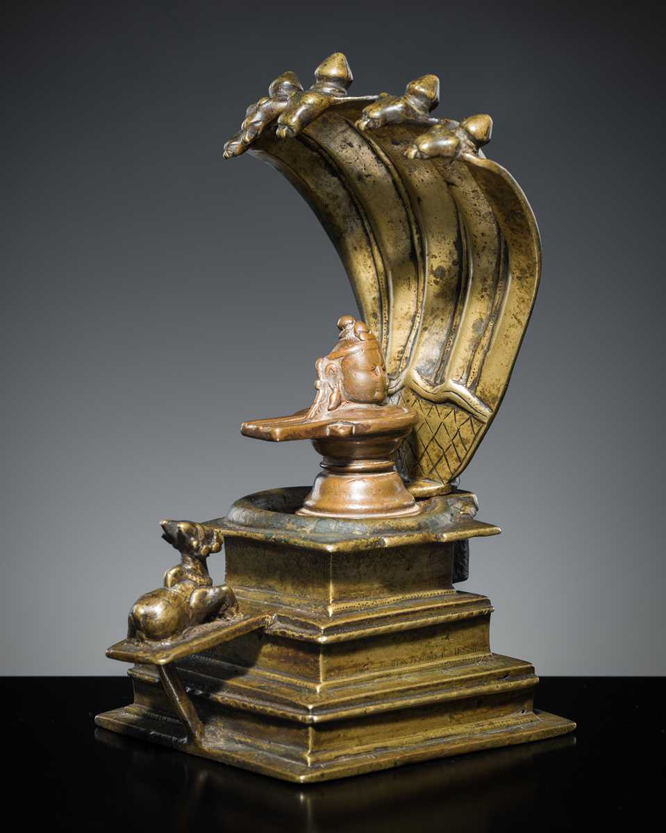Lot 178 - A COPPER SHIVA MUKHALINGAM AND A BRONZE YONI WITH NANDI AND FIVE-HEADED NAGA CANOPY, MAHARASHTRA, 17TH AND 18TH CENTURY