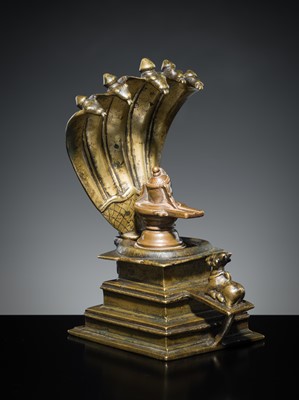 Lot 178 - A COPPER SHIVA MUKHALINGAM AND A BRONZE YONI WITH NANDI AND FIVE-HEADED NAGA CANOPY, MAHARASHTRA, 17TH AND 18TH CENTURY