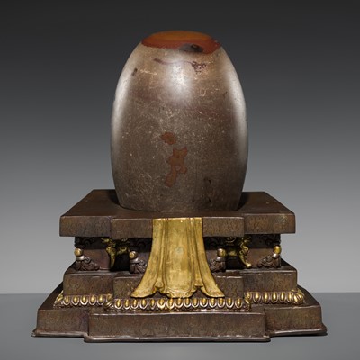 Lot 62 - A STONE ‘COSMIC EGG’ WITH A PARCEL-GILT BRONZE STAND