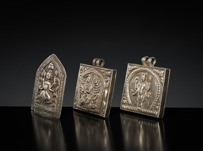 Lot 201 - A GROUP OF TWO SILVER REPOUSSÉ AMULET PENDANTS AND A PILGRIMAGE PLAQUE, 19TH-EARLY 20TH CENTURY