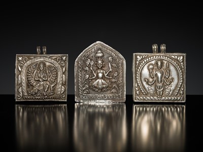 Lot 201 - A GROUP OF TWO SILVER REPOUSSÉ AMULET PENDANTS AND A PILGRIMAGE PLAQUE, 19TH-EARLY 20TH CENTURY