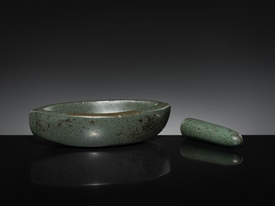 Lot 189 - A DARK GREEN STONE EYE-SHAPED MORTAR AND PESTLE