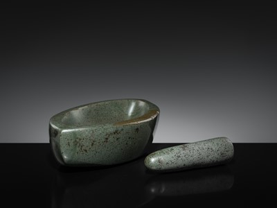 Lot 189 - A DARK GREEN STONE EYE-SHAPED MORTAR AND PESTLE