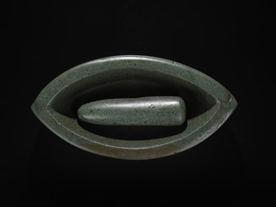 Lot 189 - A DARK GREEN STONE EYE-SHAPED MORTAR AND PESTLE