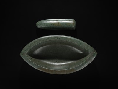 Lot 189 - A DARK GREEN STONE EYE-SHAPED MORTAR AND PESTLE