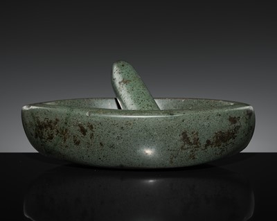 Lot 189 - A DARK GREEN STONE EYE-SHAPED MORTAR AND PESTLE