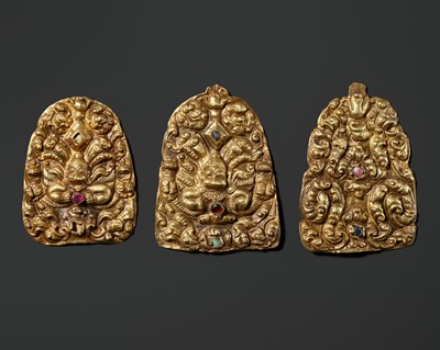 Lot 649 - A GROUP OF THREE GOLD REPOUSSÉ AND GEMSTONE-SET CROWN ORNAMENTS