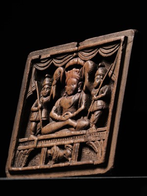 Lot 189 - A SANDALWOOD VOTIVE PLAQUE OF A CROWNED BUDDHA, WEST INDIA, 1ST MILLENNIUM AD