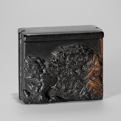 Lot 29 - MASANAO: A RARE EBONY WOOD TONKOTSU WITH SHISHI AND PEONIES (BOTAN SHISHI)